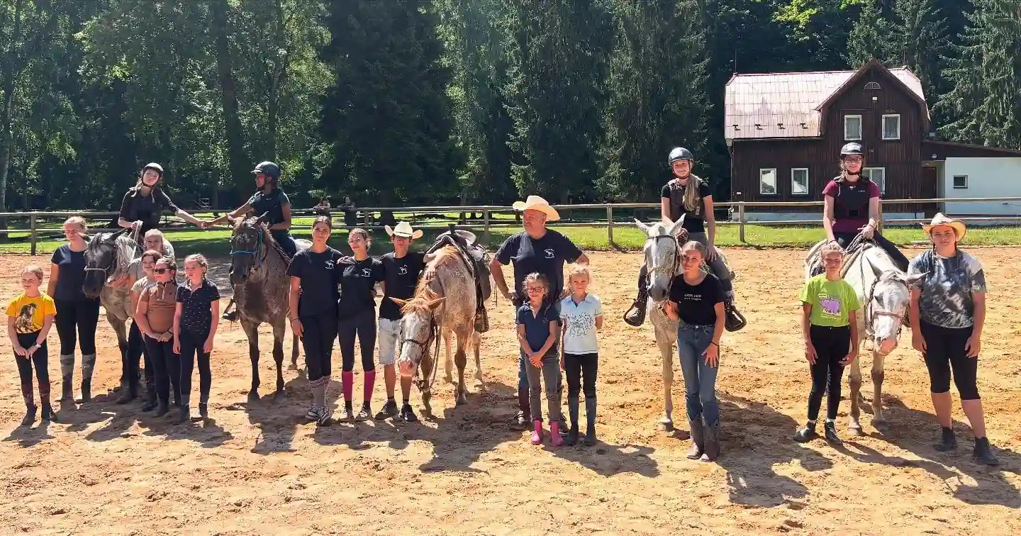 Skupina dětí s koňmi a instruktory
